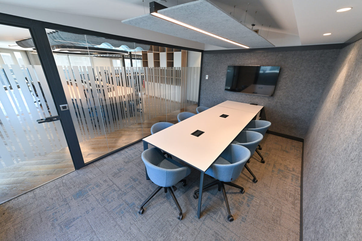 Meeting room with gray acoustic wall panels and a suspended acoustic ceiling panel above the conference table